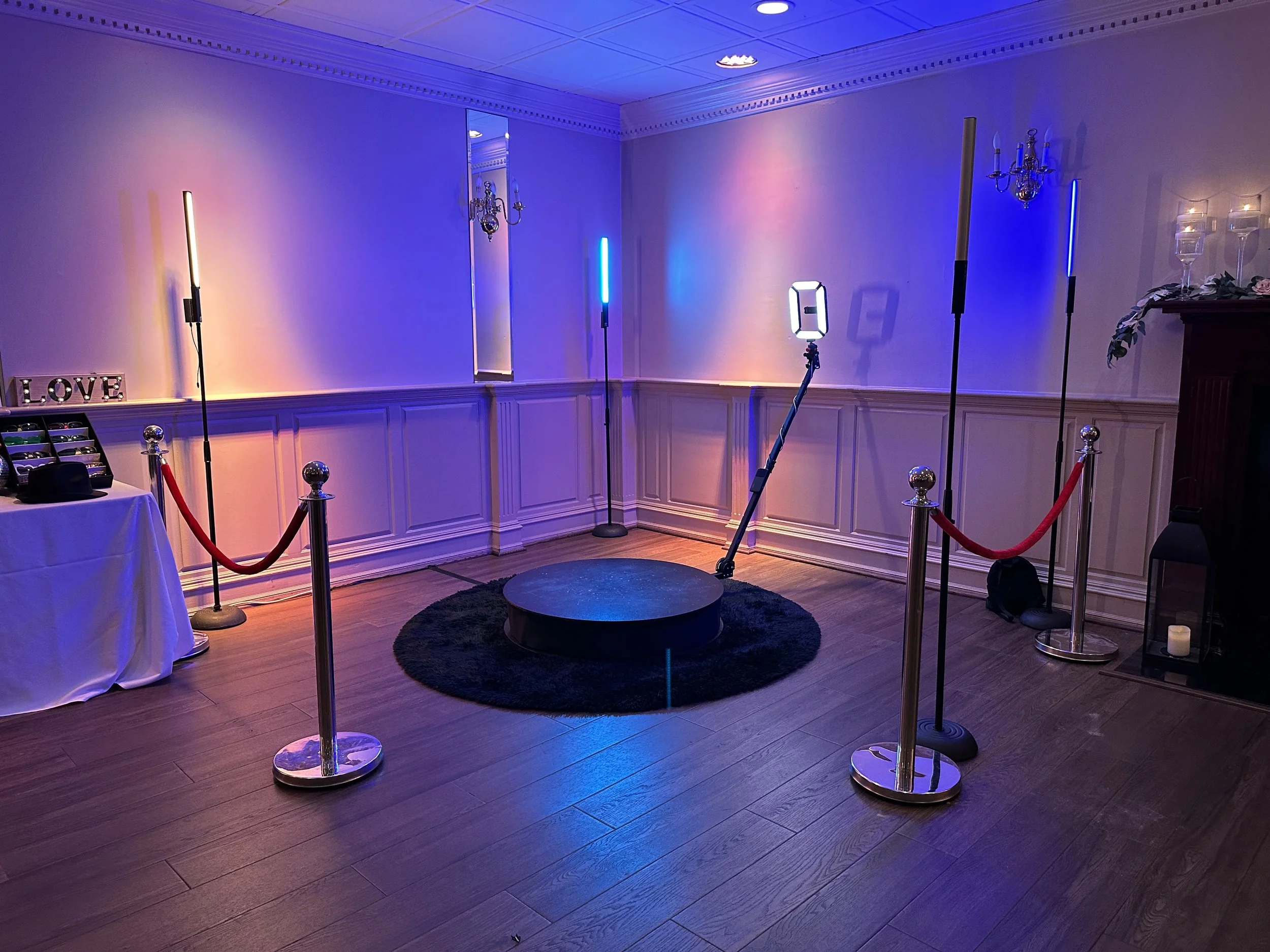 360 video booth with colored lighting and velvet ropes